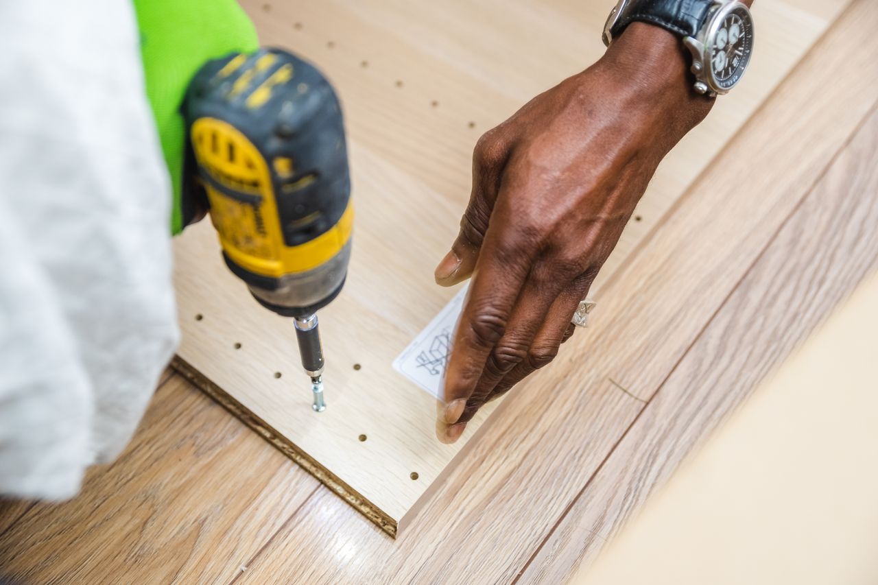 The Art of Drawing Readers In: Your attractive post title goes here A close-up view of a craftsperson using a drill on a wooden board, showcasing precise carpentry work.
