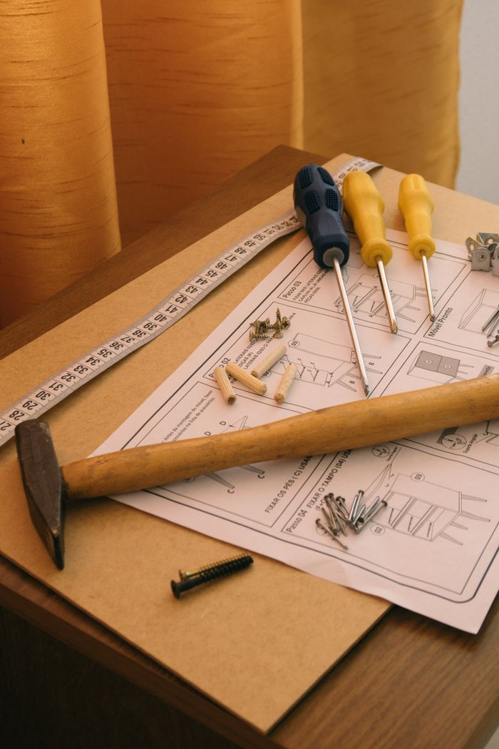 Mastering the First Impression: Your intriguing post title goes here A set of tools and instructions for assembling DIY furniture, including a hammer and screwdrivers.